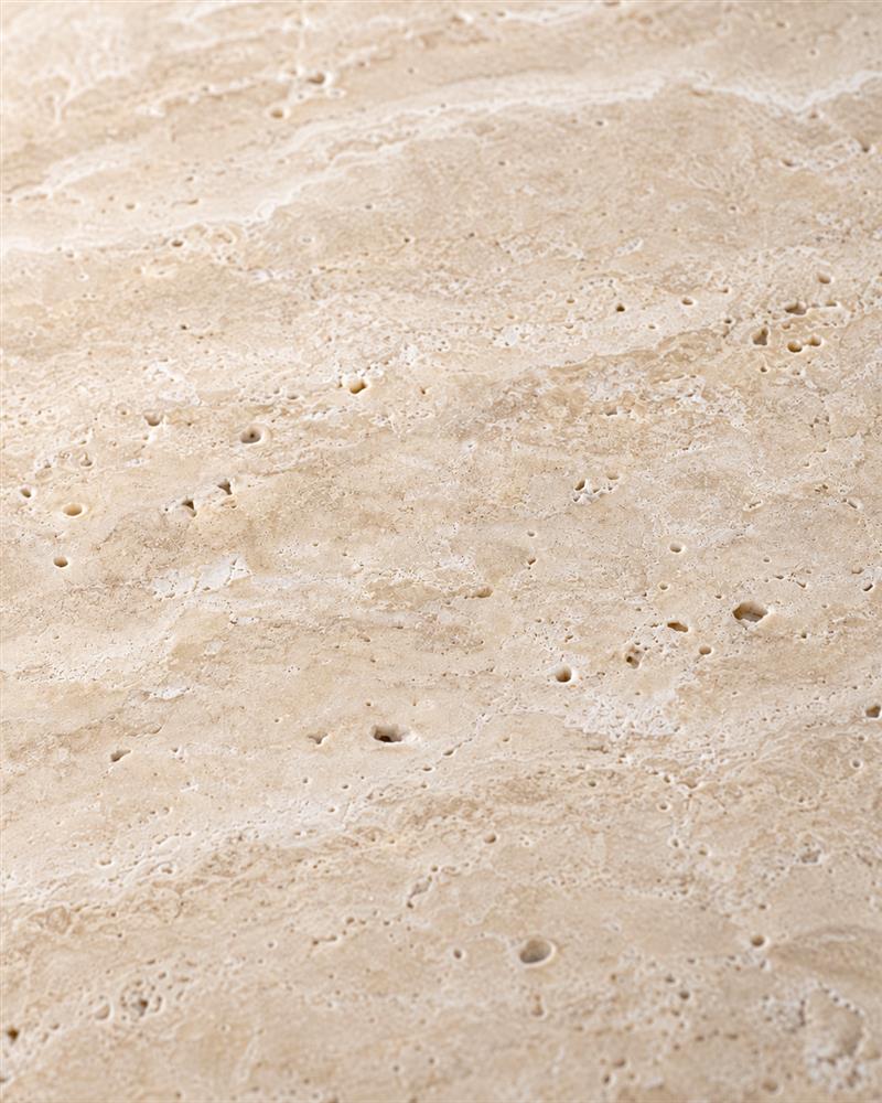 Close-up of beige travertine natural pores and subtle stone veining