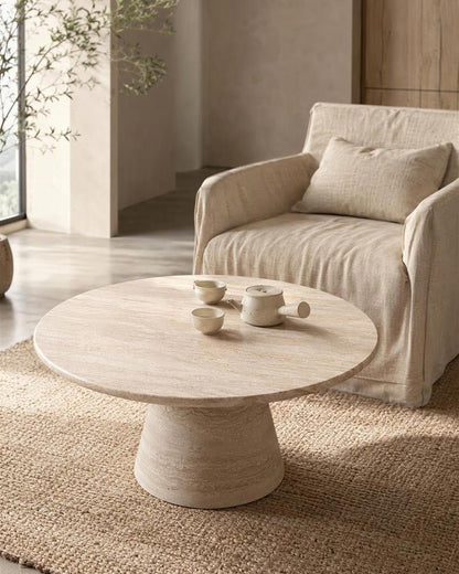 Beige travertine pedestal coffee table with a ceramic tea set