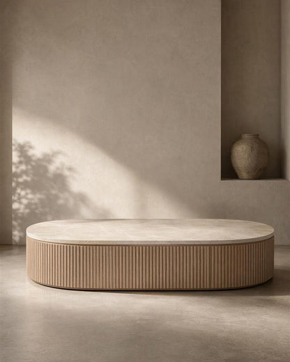 Oval Taj Mahal coffee table with fluted wooden base in warm natural light