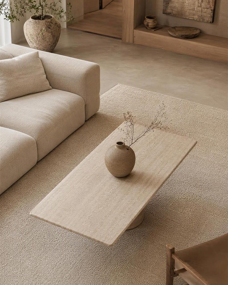 Rectangular travertine coffee table styled in a neutral living room