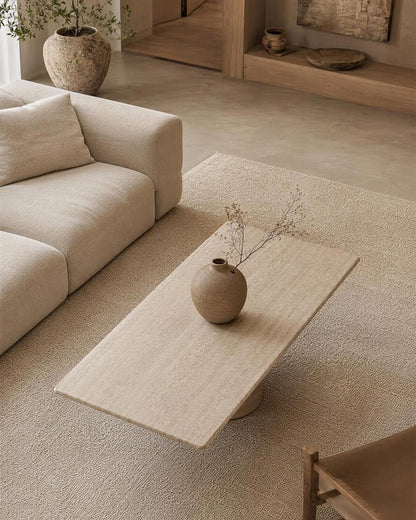 Rectangular travertine coffee table styled in a neutral living room