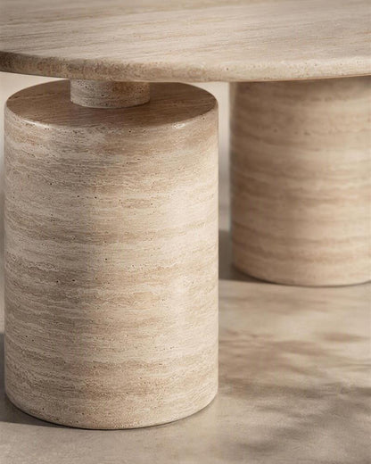 Close-up of beige travertine stepped cylindrical pedestal and tabletop
